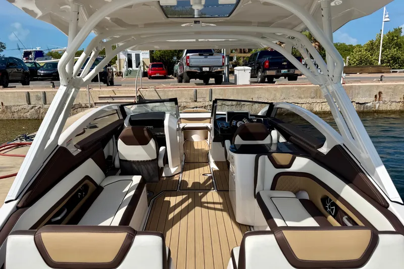 Slide: The Image of 2022 Yamaha Boats 275SD interior with luxurious seating and modern design at a dock. - 16