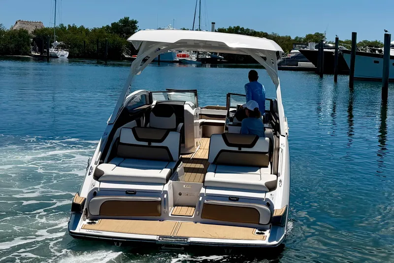 Slide: The Image of 2022 Yamaha Boats 275SD cruising on a calm, sunny waterway. - 2