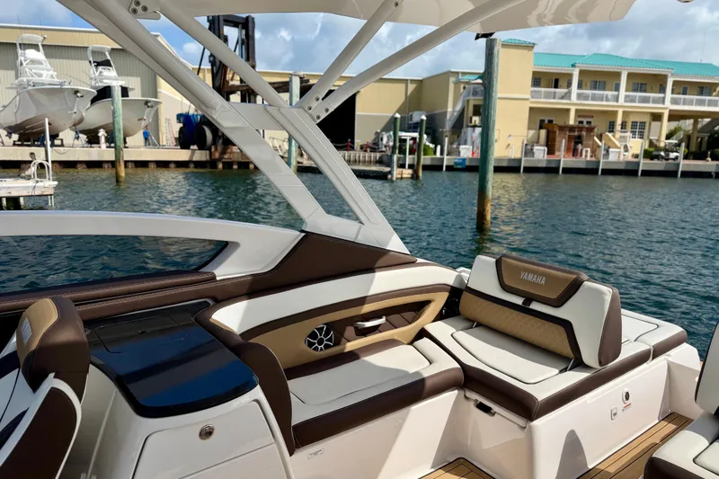Slide: The Image of 2022 Yamaha Boats 275SD interior with luxurious seating, dockside view. - 25