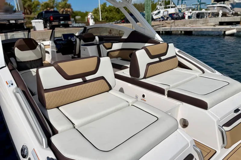 Slide: The Image of 2022 Yamaha Boats 275SD interior with luxurious seating and modern design at a marina. - 31