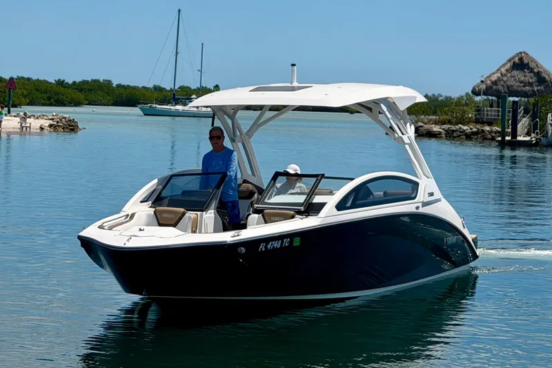 Slide: The Image of 2022 Yamaha Boats 275SD cruising on calm waters with scenic background. - 6