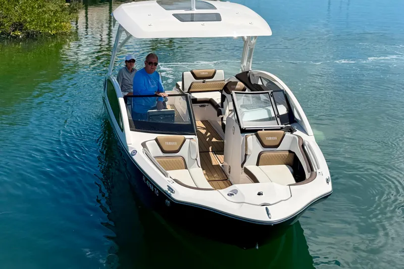 Slide: The Image of 2022 Yamaha Boats 275SD cruising on calm water with passengers onboard. - 7