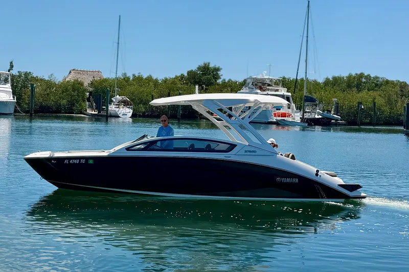 Slide: The Image of 2022 Yamaha Boats 275SD cruising on a sunny day in a marina. - 9