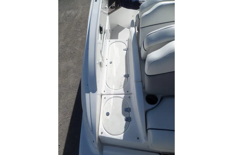 Slide: The Image of 2013 Rinker 296 Captiva Cuddy boat interior with white seating and storage compartments. - 11