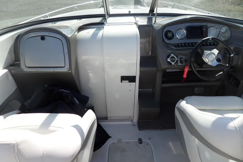 Slide: The Image of 2013 Rinker 296 Captiva Cuddy boat interior with steering wheel and dashboard controls. - 13