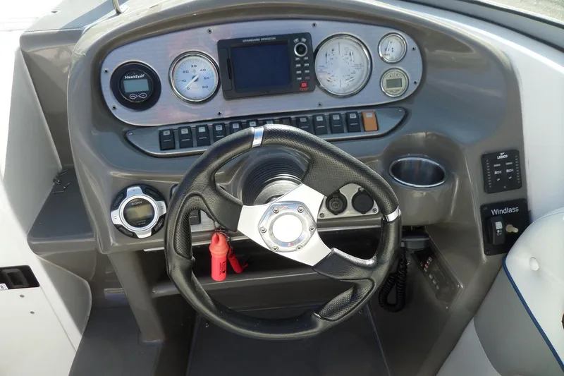 Slide: The Image of Steering console of 2013 Rinker 296 Captiva Cuddy boat with gauges and controls. - 14