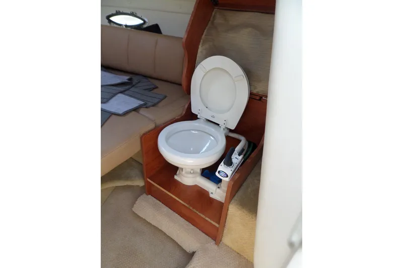 Slide: The Image of 2013 Rinker 296 Captiva Cuddy boat interior with compact marine toilet. - 28