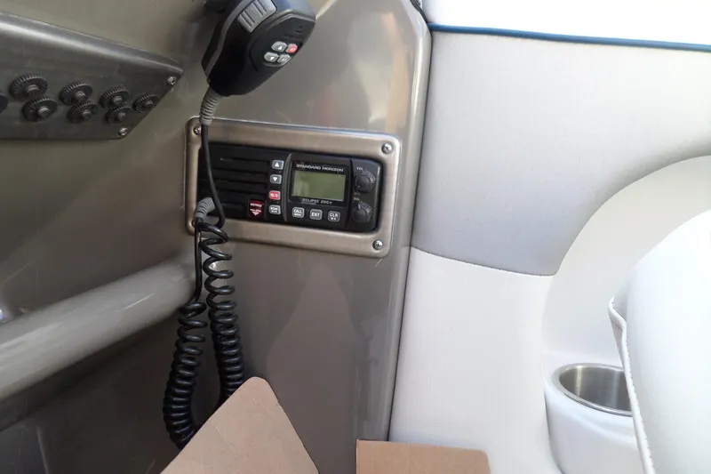 Slide: The Image of 2013 Rinker 296 Captiva Cuddy boat interior with radio and control panel. - 34