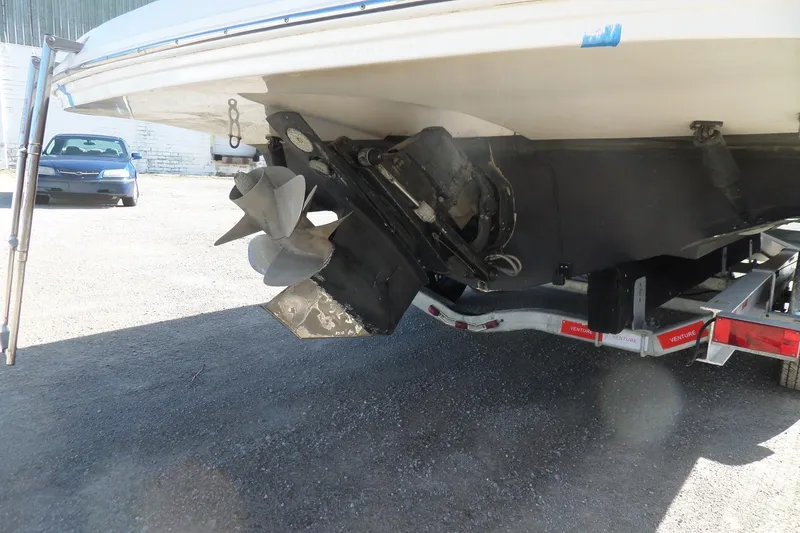 Slide: The Image of 2013 Rinker 296 Captiva Cuddy boat on trailer, showing propeller and stern drive. - 4