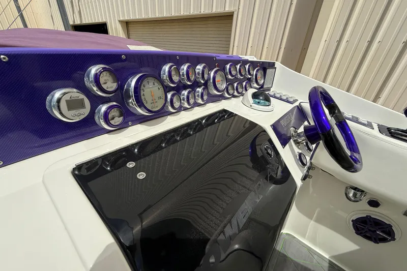 Slide: The Image of 1997 Powerplay Powerboats 33 Sport Deck dashboard with purple accents and multiple gauges. - 11