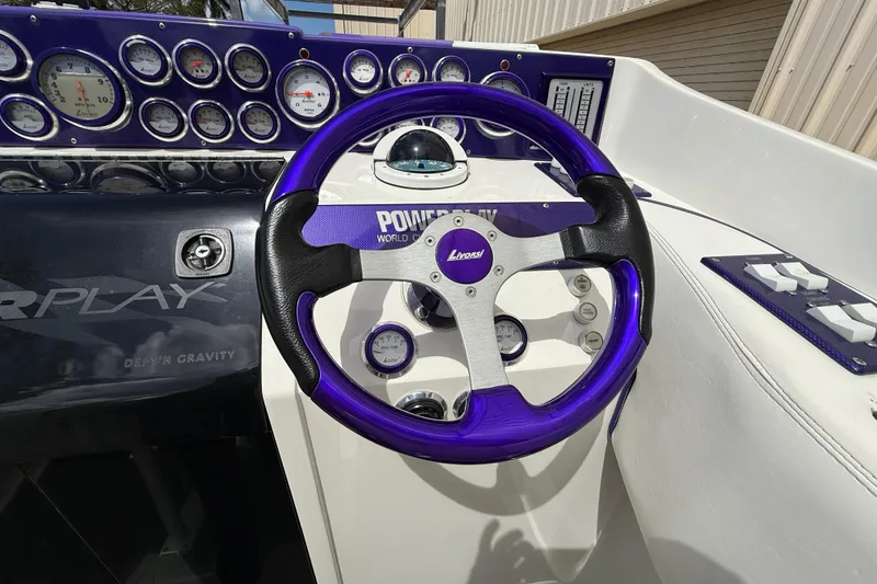 Slide: The Image of 1997 Powerplay Powerboats 33 Sport Deck cockpit with purple steering wheel and gauges. - 12