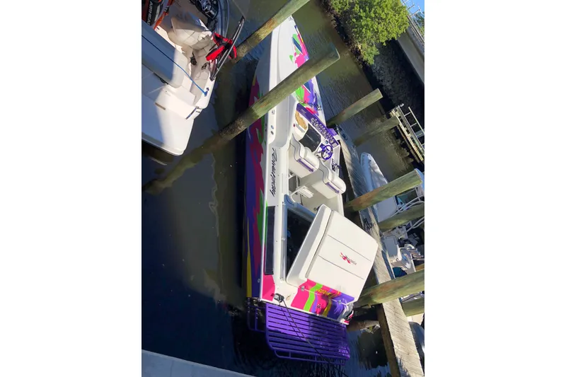 Slide: The Image of 1997 Powerplay Powerboats 33 Sport Deck with vibrant colors docked at a marina. - 7