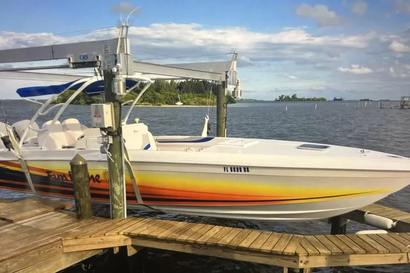 The Image of 2007 Renegade 29CC boat docked, featuring vibrant orange and yellow design. - 1