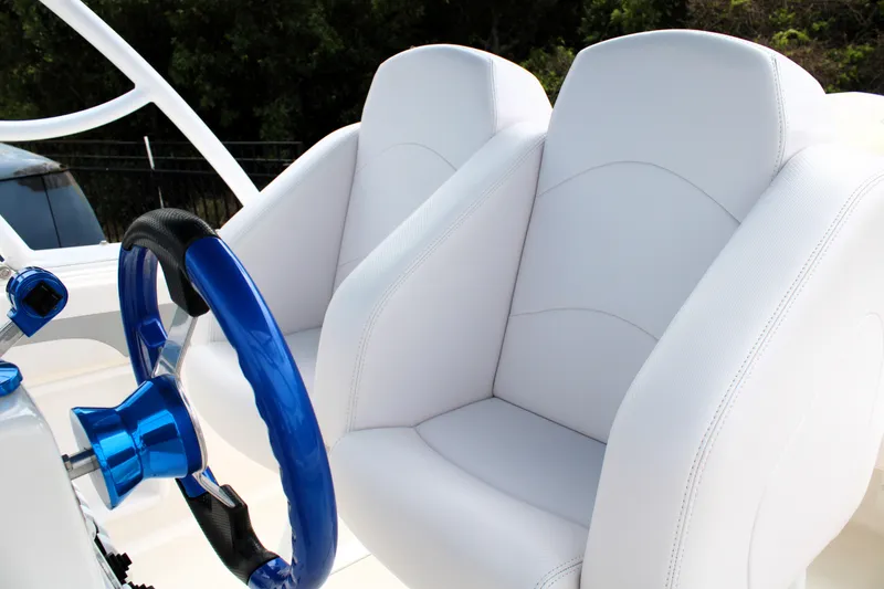 Slide: The Image of White leather seats and blue steering wheel in 2007 Renegade 29CC boat cockpit. - 25