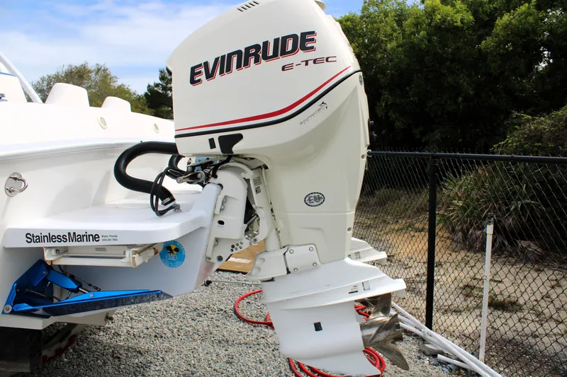 Slide: The Image of 2007 Renegade 29CC boat with Evinrude E-TEC outboard motor, parked on gravel. - 49
