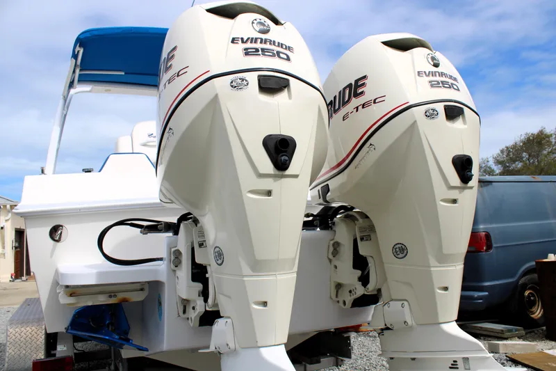 Slide: The Image of 2007 Renegade 29CC boat with dual Evinrude 250 E-TEC engines, docked outdoors. - 50