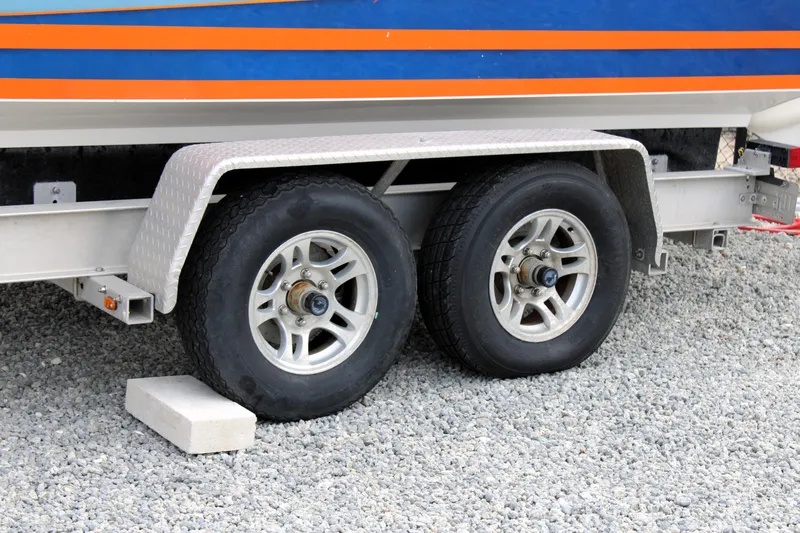 Slide: The Image of Trailer wheels of a 2007 Renegade 29CC boat on gravel surface. - 54