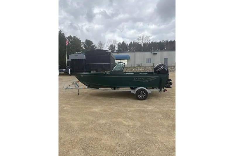 The Image of 2026 Lund 1700 Explorer Sport boat on trailer, parked outdoors under cloudy sky. - 1
