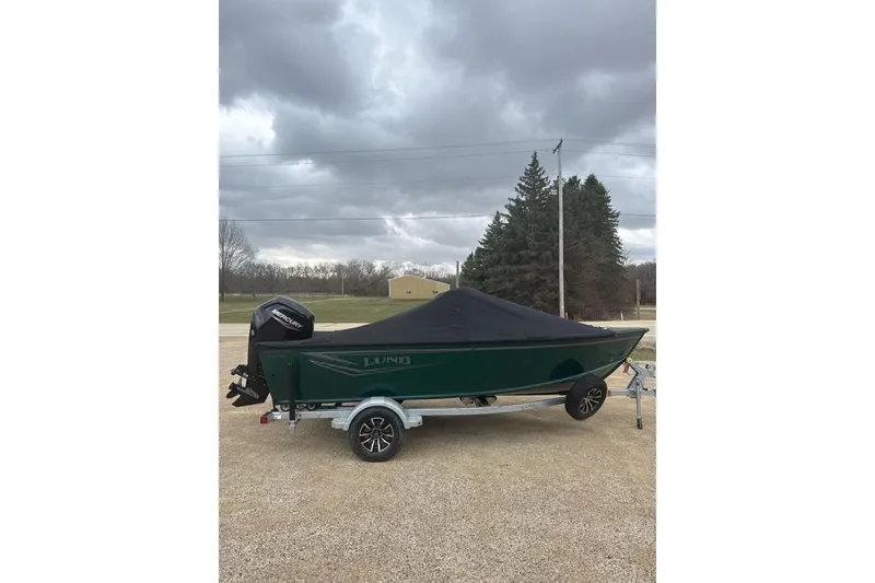 Slide: The Image of 2026 Lund 1700 Explorer Sport boat on trailer under cloudy sky. - 14