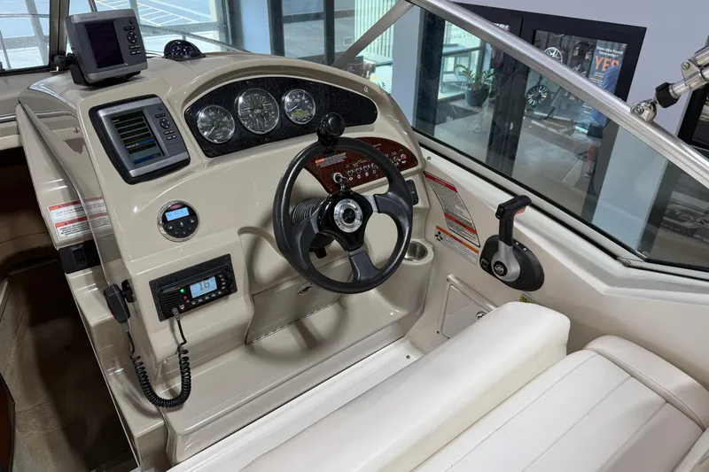 Slide: The Image of 2009 Sea Ray 240 Sundancer boat cockpit with steering wheel and control panel. - 13