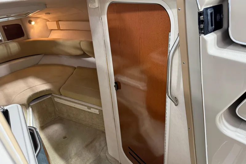 Slide: The Image of Interior cabin of 2009 Sea Ray 240 Sundancer with beige seating and wooden door. - 18