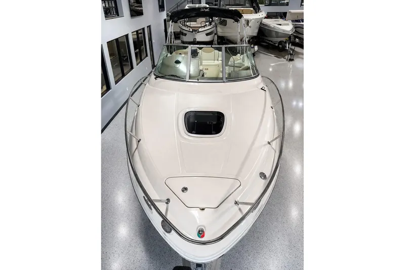 Slide: The Image of 2009 Sea Ray 240 Sundancer boat displayed indoors, showcasing sleek design and spacious deck. - 2