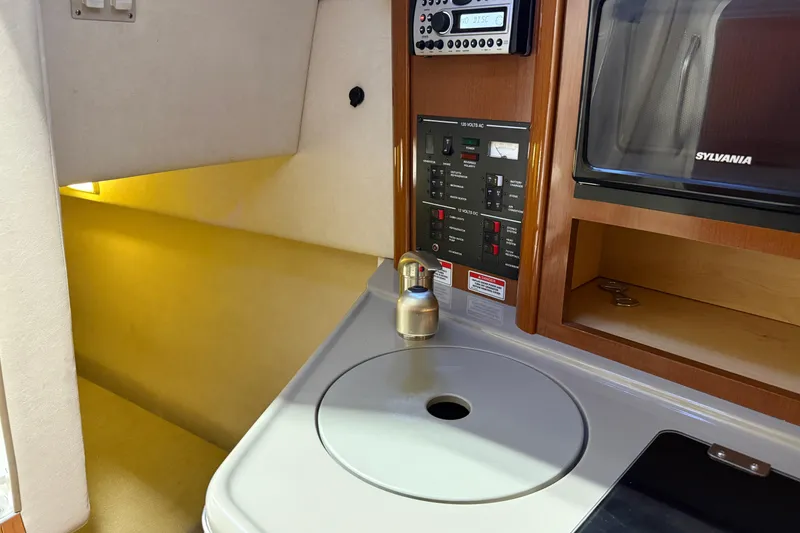 Slide: The Image of 2009 Sea Ray 240 Sundancer cabin interior with control panel and kitchenette area. - 21