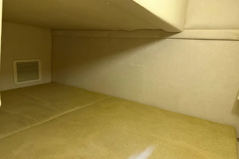 Slide: The Image of Interior cabin of 2009 Sea Ray 240 Sundancer boat, featuring beige upholstery. - 24