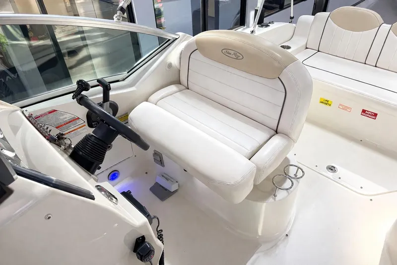 Slide: The Image of Interior of 2009 Sea Ray 240 Sundancer boat, featuring helm and seating area. - 27