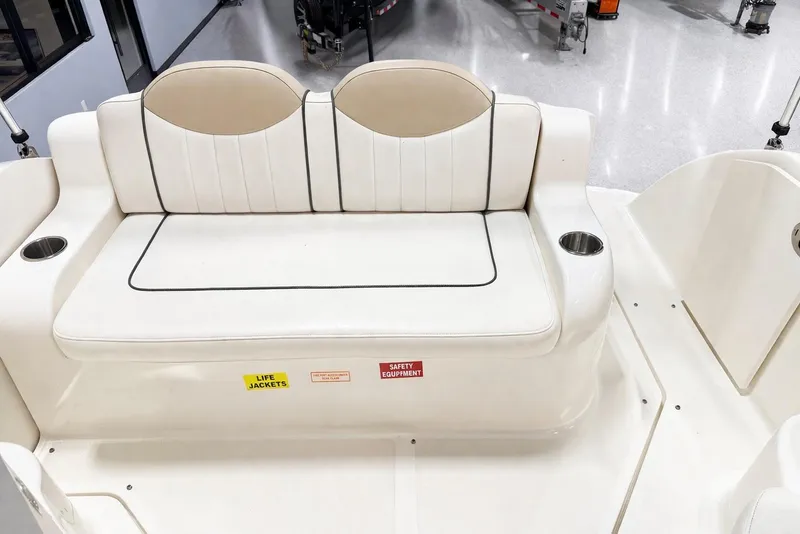 Slide: The Image of 2009 Sea Ray 240 Sundancer boat interior with white seating and cup holders. - 29