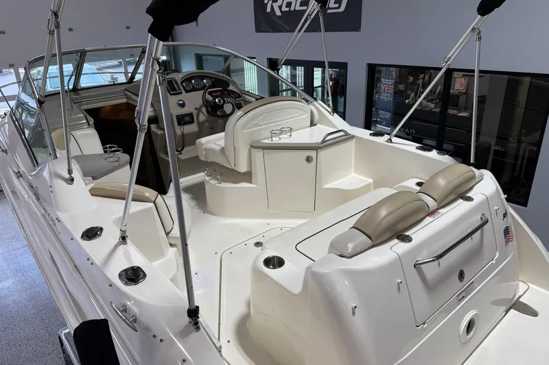 Slide: The Image of 2009 Sea Ray 240 Sundancer boat interior with seating and helm, showcasing luxury design. - 11