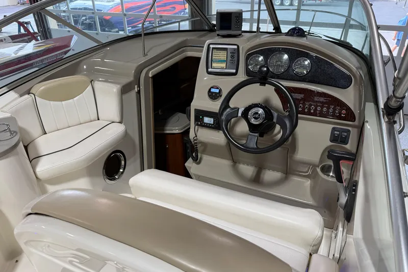 Slide: The Image of 2009 Sea Ray 240 Sundancer boat cockpit with steering wheel and navigation controls. - 14