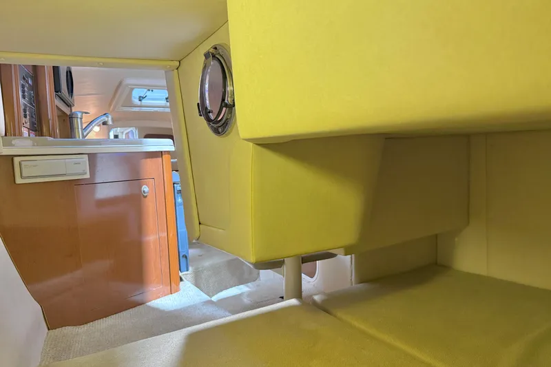 Slide: The Image of Interior of 2009 Sea Ray 240 Sundancer boat, featuring kitchenette and seating area. - 25