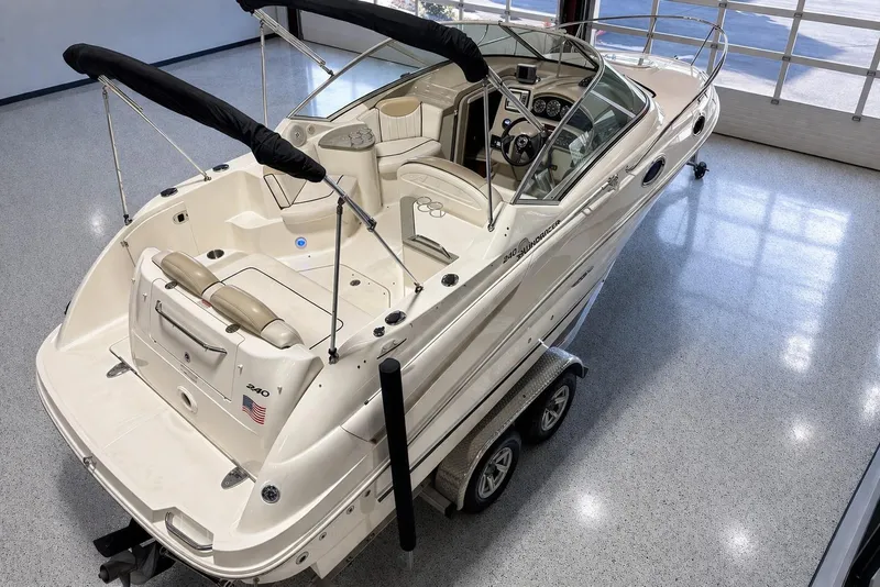 Slide: The Image of 2009 Sea Ray 240 Sundancer boat on trailer in showroom, featuring sleek design and spacious interior. - 4