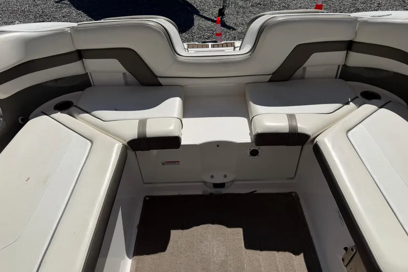 Slide: The Image of 2016 Yamaha Boats 242 Limited S interior seating with beige upholstery and cup holders. - 16