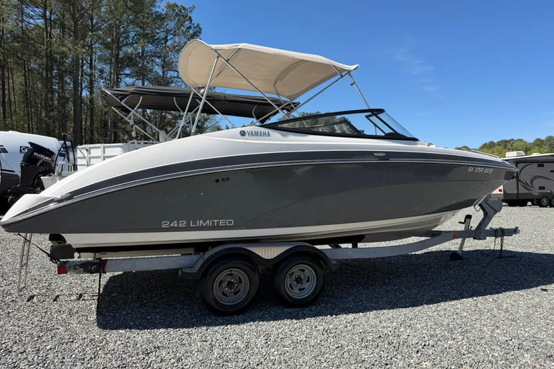 Slide: The Image of 2016 Yamaha Boats 242 Limited S on trailer, parked outdoors under clear sky. - 24