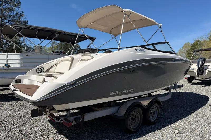 Slide: The Image of 2016 Yamaha Boats 242 Limited S on trailer, parked outdoors under clear sky. - 3