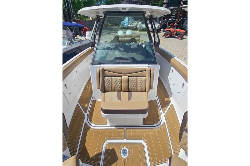 Slide: The Image of 2026 Monterey Elite 30 OB boat interior with tan seating and wood-style flooring. - 23
