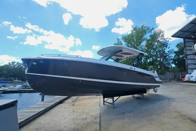 Slide: The Image of 2026 Monterey Elite 30 OB boat docked under a bright blue sky. - 4