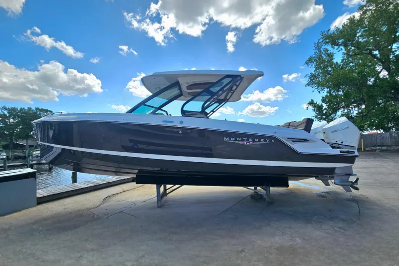 Slide: The Image of 2026 Monterey Elite 30 OB boat on display under a bright blue sky. - 5