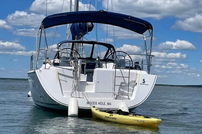 Slide: The Image of Beneteau Oceanis 46 sailboat, 2007 model, anchored with kayak, under blue sky. - 27