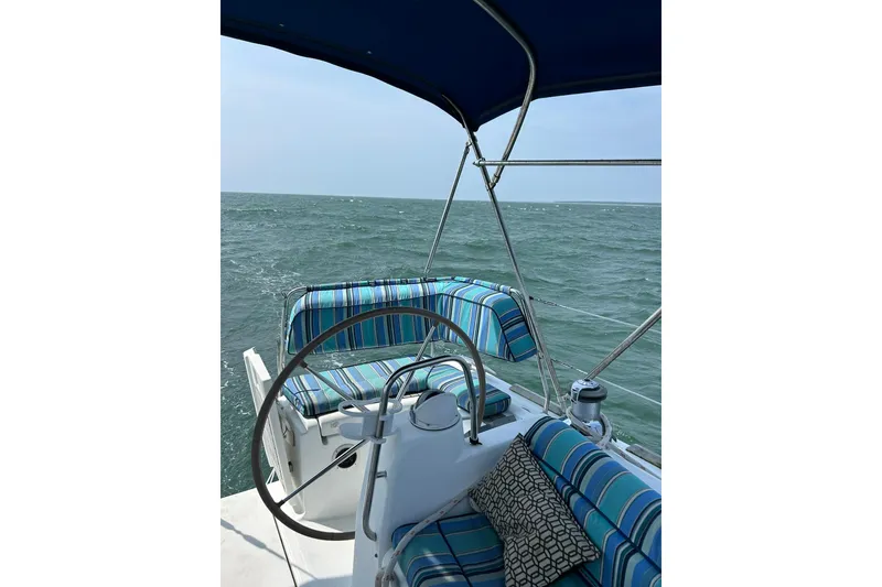 Slide: The Image of Cockpit view of 2007 Beneteau Oceanis 46 sailboat with striped cushions on open sea. - 6