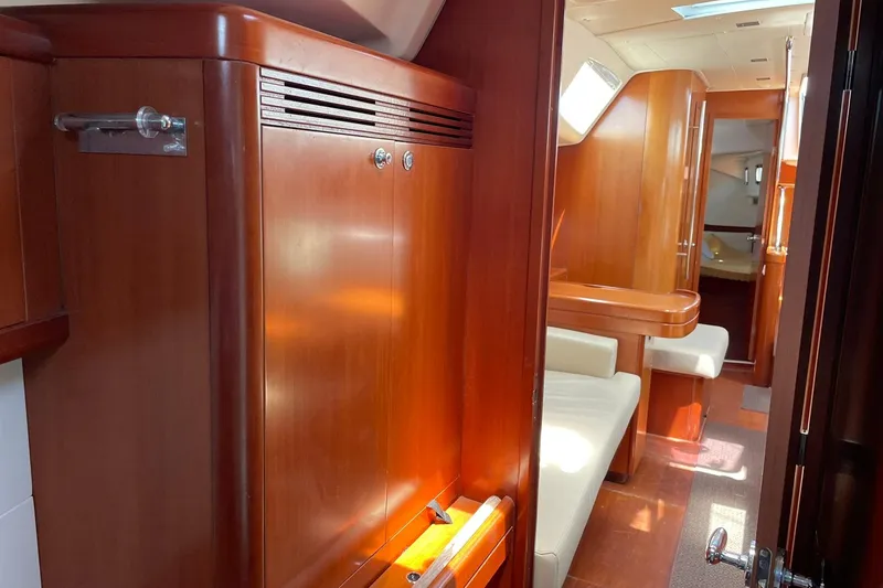 Slide: The Image of Interior of 2007 Beneteau Oceanis 46 yacht with wooden cabinetry and seating area. - 24