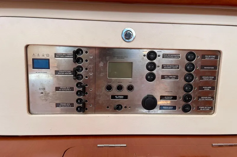 Slide: The Image of Control panel of a 2007 Beneteau Oceanis 46 sailboat, featuring various switches and indicators. - 34