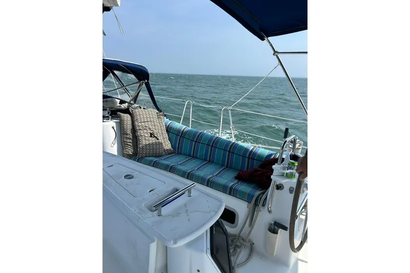 Slide: The Image of 2007 Beneteau Oceanis 46 sailboat cockpit with striped seating, cruising on open water. - 8