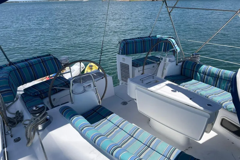 Slide: The Image of 2007 Beneteau Oceanis 46 sailboat cockpit with striped seating, dual steering wheels, and ocean view. - 45