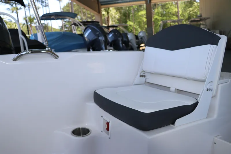 Slide: The Image of 2026 Robalo R160 Center Console boat seat with cup holder, in a marina setting. - 12