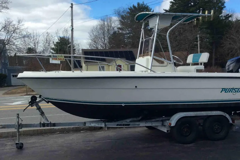 Slide: The Image of 1992 Pursuit 2150 Center Console boat on trailer, for sale sign visible. - 2