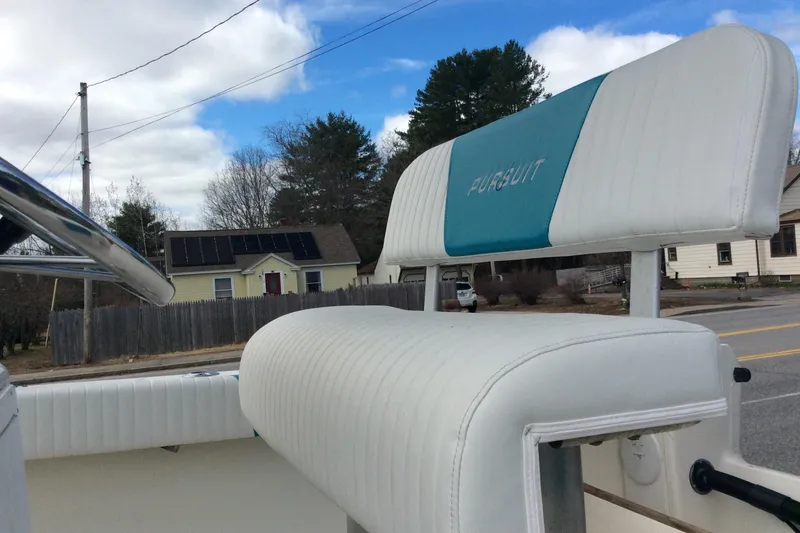 Slide: The Image of 1992 Pursuit 2150 Center Console boat seat with logo, parked near residential area. - 5
