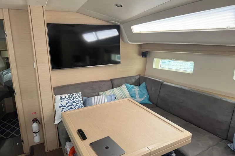 Slide: The Image of Interior of a 2018 Jeanneau 51 yacht with modern seating and a wall-mounted TV. - 22